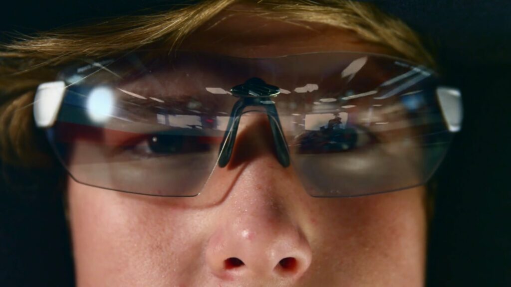 Close up of man with safety glasses staring above camera