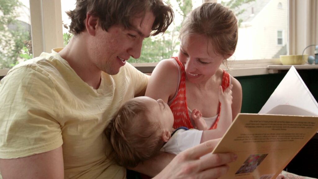 Mother father and baby reading a book